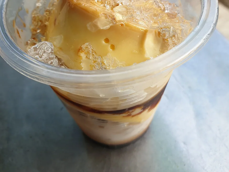 คัสตาร์ดคาราเมลเวียดนามในถ้วยกับกาแฟดำและน้ำแข็งบด