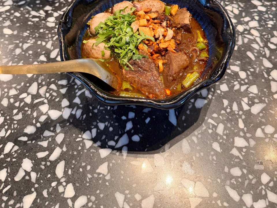 ก๋วยเตี๋ยวเรือเนื้อน้ำเข้มกับเส้น เนื้อน่อง ลูกชิ้น ผักบุ้ง ถั่วงอก โหระพา ขึ้นฉ่าย และกระเทียมเจียว