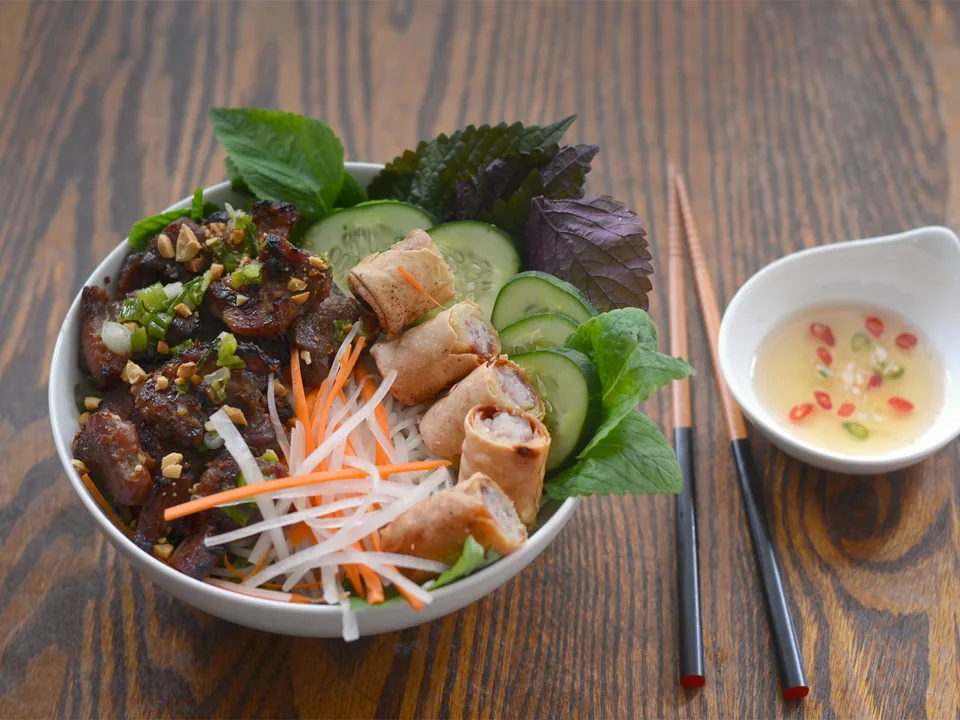 เส้นข้าวหมูย่างกับผักกาด แตงกวา ผักดองและถั่วลิสง