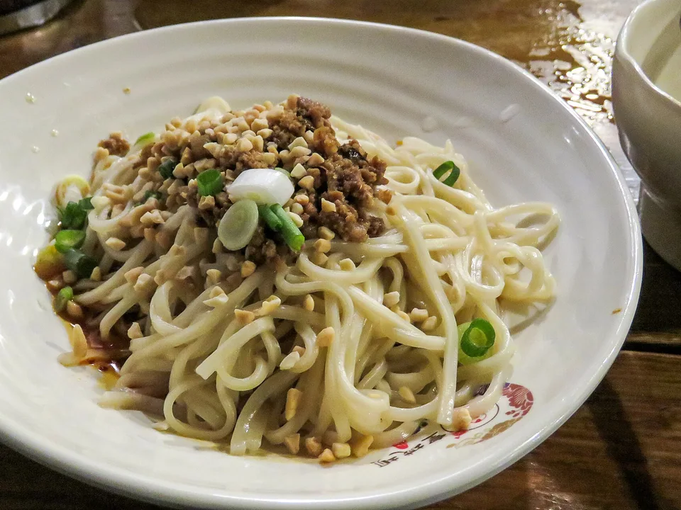 บะหมี่ตันตันคลุกซอสงาพริก ท็อปด้วยหมูผัด ต้นหอม และถั่วลิสงบด