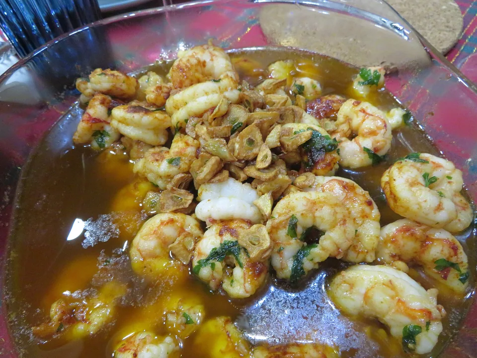 กุ้งสีชมพูเดือดฉ่าในน้ำมันมะกอกกระเทียมพริกสีทองกับพาร์สลีย์