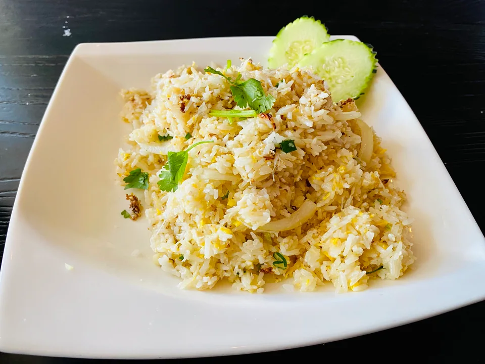 ข้าวผัดปูสีทองอ่อนกับไข่ ต้นหอม แตงกวา มะเขือเทศ และมะนาว