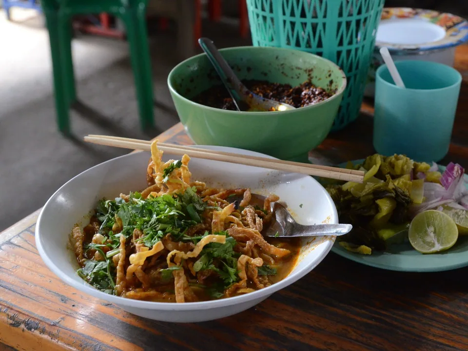 ข้าวซอยไก่เชียงใหม่กับน่อง กะทิ บะหมี่ลวก บะหมี่กรอบ ผักกาดดอง หอม และมะนาว