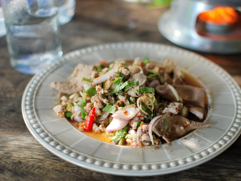 ลาบหมูกับหมูสุก ข้าวคั่ว หอมแดง สะระแหน่ ผักชี มะนาว และพริก