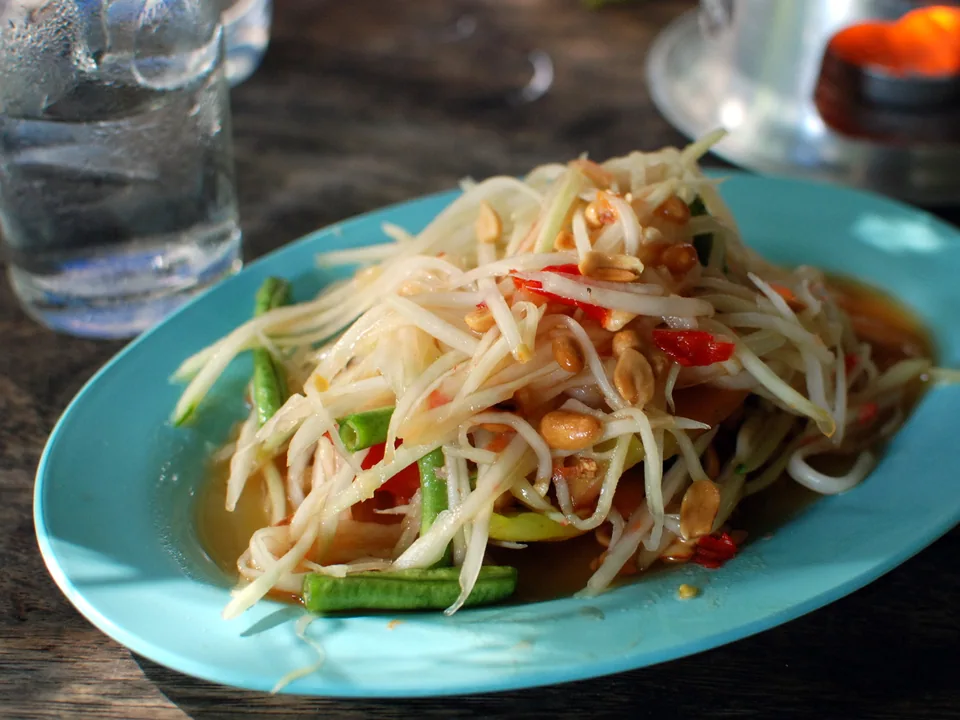 ส้มตำไทยกับมะละกอ มะเขือเทศ ถั่วฝักยาว กุ้งแห้ง ถั่ว มะนาว และพริก