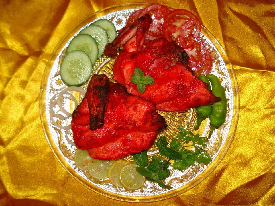 ไก่ทันดูรีสีส้มแดงมีรอยเกรียมกับชัตนีย์สะระแหน่ หอมซอย และเลมอน