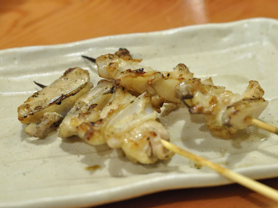 ยากิโทริไก่ย่างเกลือสีอ่อนบนจานเซรามิกสีอ่อน